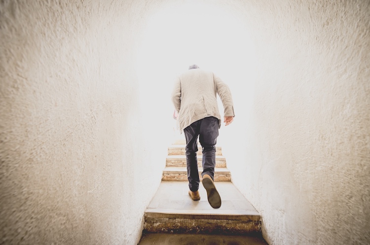 Jason Goodwin walking up backlit stairs in an old lighthouse
